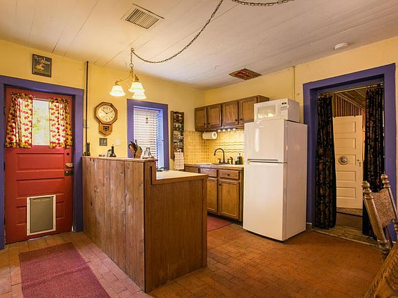 Kitchen and Nook. Note the original brick flooring in kitchen, and hardwood in bedroom.