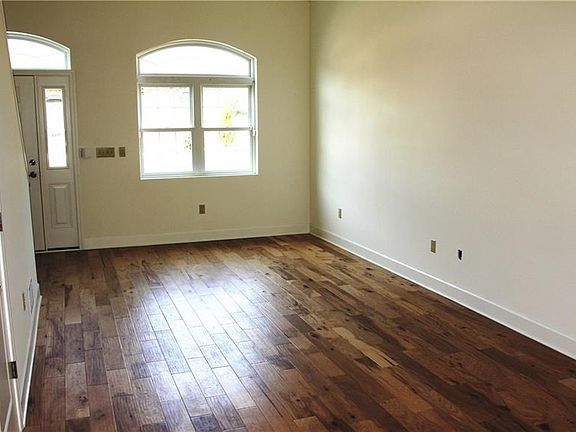 Spacious living room with gleaming hickory wood floors.