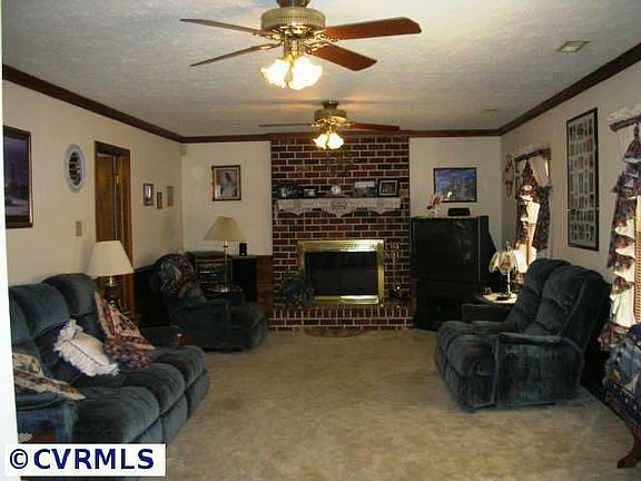 Large den with fireplace overlooking front yard.