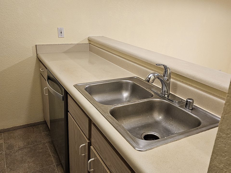 Kitchen view on sink, dishwasher and bar counter.