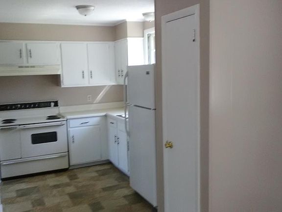 Kitchen features stove, refrigerator