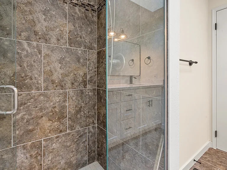 Great-sized master bedroom with a beautifully remodeled ensuite, showcasing a double-sink vanity and a sleek, modern shower.