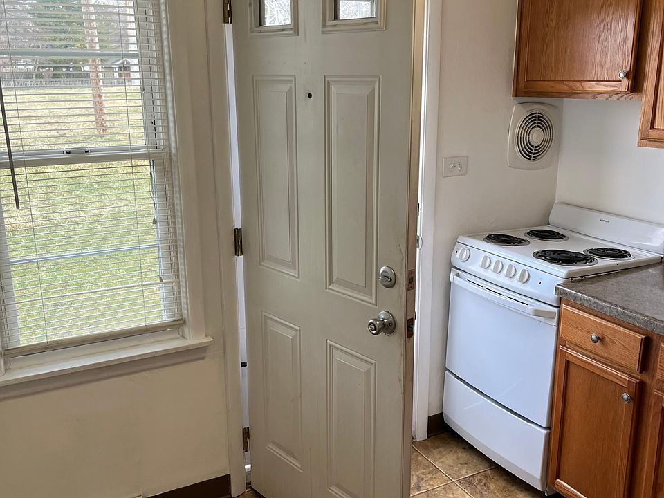 rear entry into kitchen showing window and range