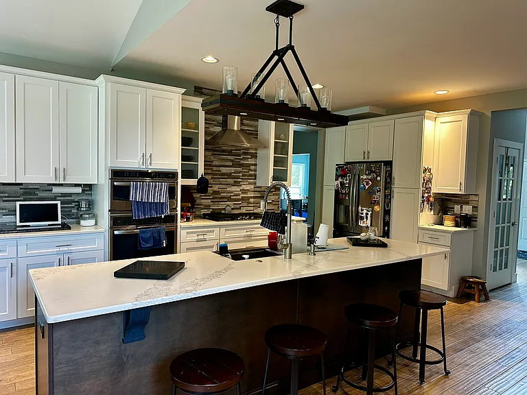 Pantry cabinets surround the stainless steel fridge for plenty of storage.
