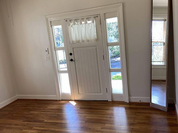 Living Room/Office Space filled with natural light. Features original flooring, fireplace (non working), ceiling fan, double paned windows & wooden Levelor blinds