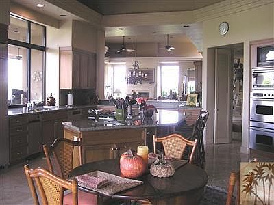 View from Family Room through kitchen into living & dining room. 14 ft. ceilings, travertine flooring, granite counters and custom cabinetry.