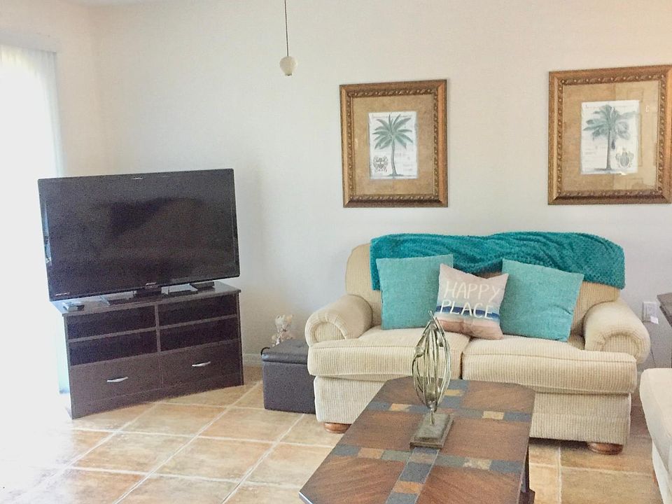 Bright and spacious open living space with sliding doors, ceiling fan, beautiful tile flooring throughout. Unit 2