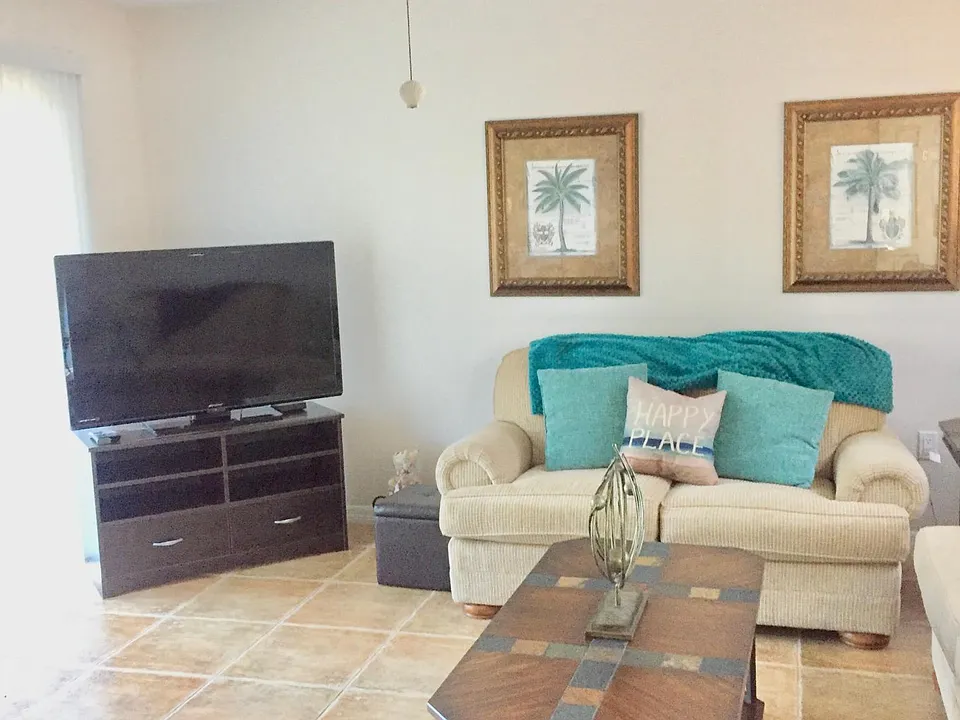 Bright and spacious open living space with sliding doors, ceiling fan, beautiful tile flooring throughout. Unit 2