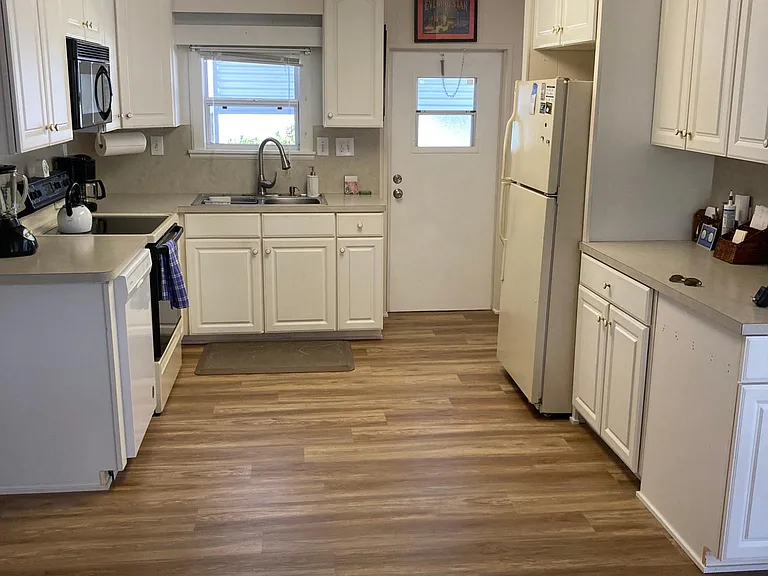Fuller shot of the kitchen and the back door to the carport and the laundry room, etc.