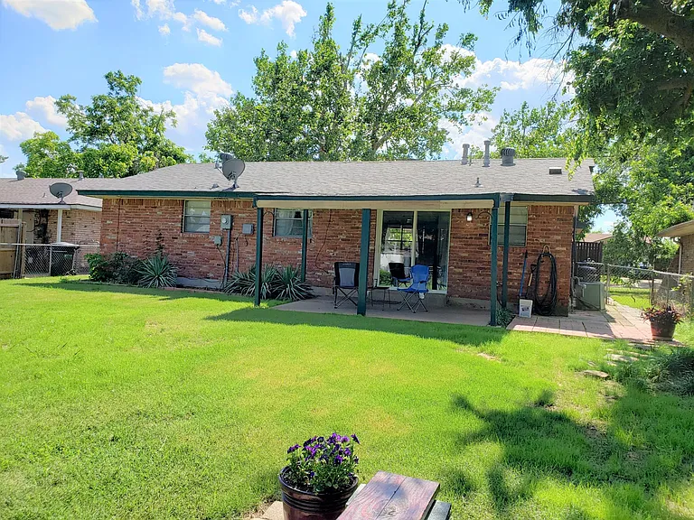 Large fenced in backyard with covered patio.