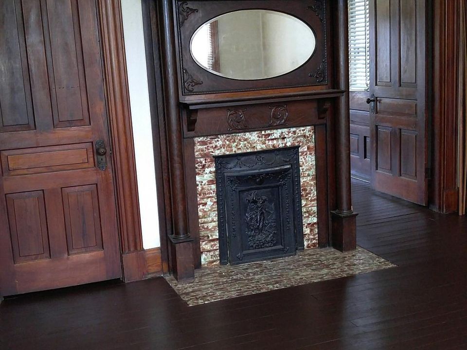 Living room with closet and antique fireplace.