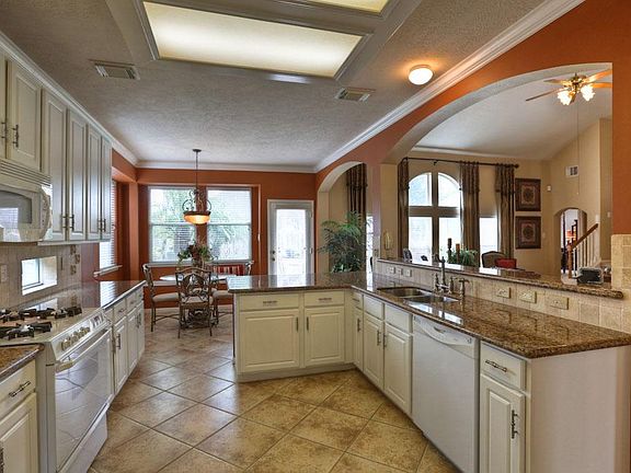 A KITCHEN 15x11 ready for a family of cooks. Wide floor space, long granite countertops, abundant upper and lower cabinetry, both walk-up serving bar and seated breakfast bar, and streaming natural light make this Kitchen a winner!