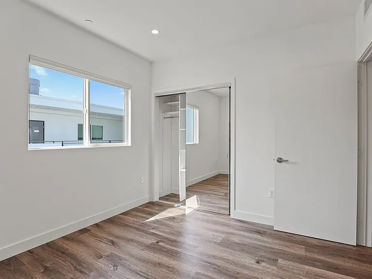 Bedroom with Mirrored Closet, Vinyl Flooring, and Window