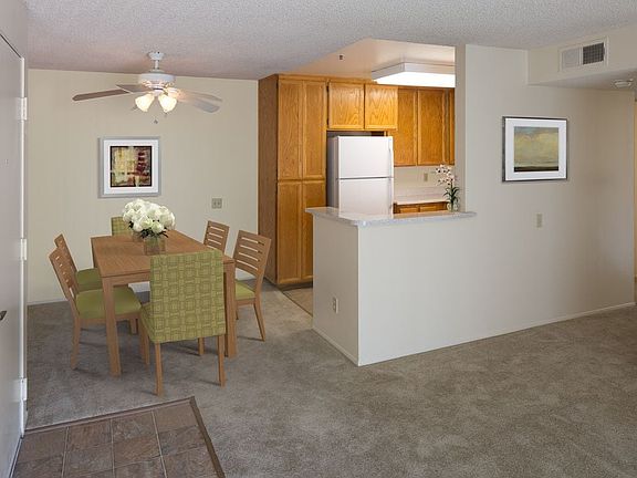 Classic Package kitchen with oak cabinetry, beige speckled laminate countertops, tile flooring, and white appliances