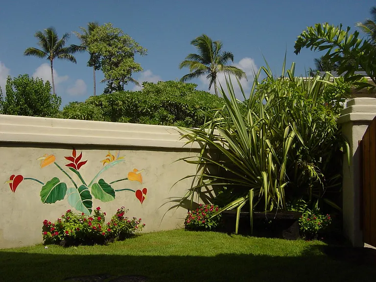 Parking for one car with stained glass detains and tropical landscaping abound.