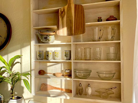 Shelf in kitchen with glasses, other essentials - beautiful natural light in entire space