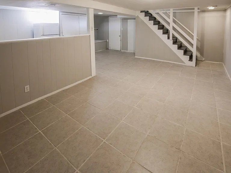 Finished basement with tile flooring.