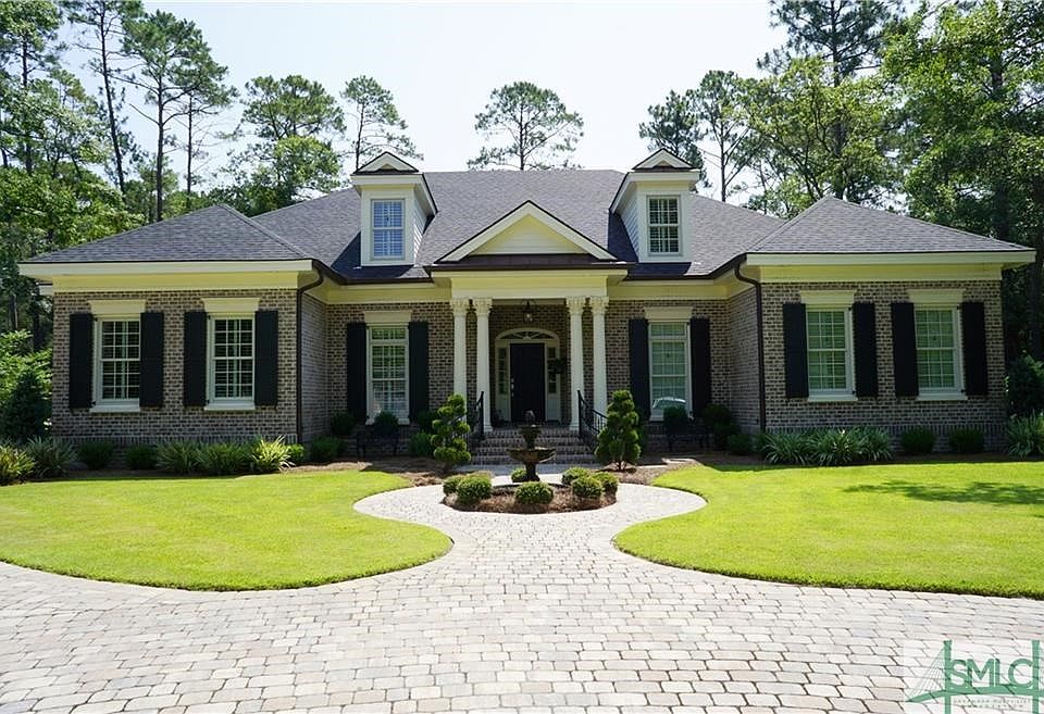 Welcome to 104 Waterway Drive, Moon River, The Landings! Spanish Moss Brick home with Windsor Pinnacle Windows, Wood Exterior Shutters, Copper gutters and downspouts, beautiful Natural Gas Light above the front door and gorgeous Paver circular driveway.