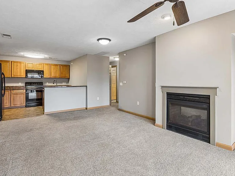 A cozy fireplace, open-concept layout, and warm finishes create a space that feels effortlessly like home.
