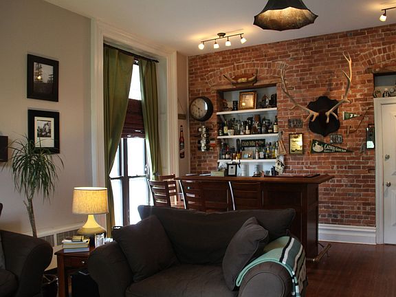 Living room, front door view, exposed brick