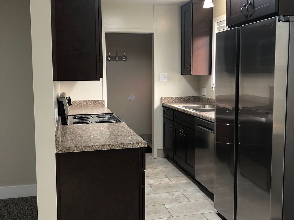 Looking into the kitchen from the dining room towards the entry way. There is a lot of work space and storage.