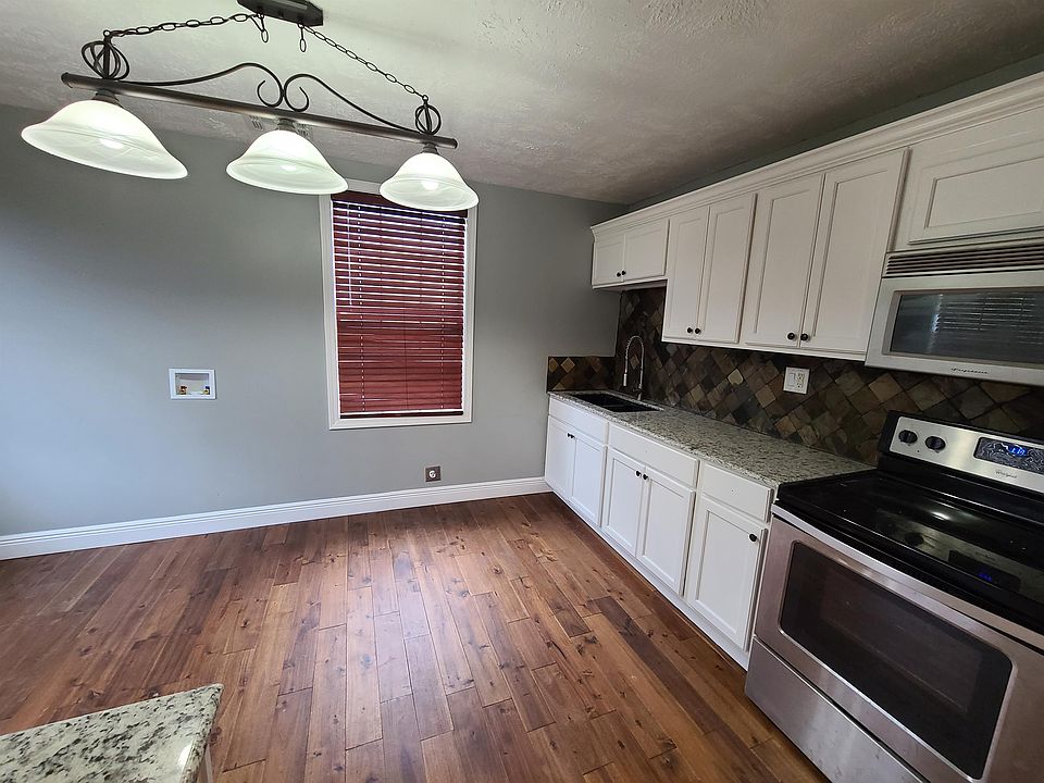 Renovated kitchen with new hardwood flooring, cabinets, granite, washer/dryer, double sink, & blinds