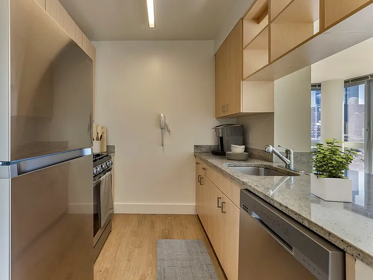 Renovated I South kitchen with stainless steel appliances, grey quartz countertops, oak cabinetry, and hard surface flooring