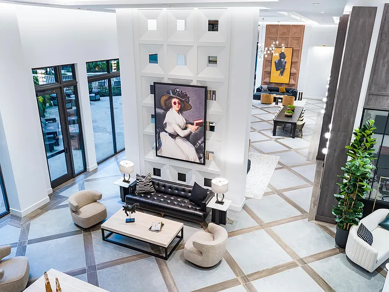 A double-height lobby at Modera Aventura, where sculptural wall detailing, gallery-style art, and layered seating create a bold yet welcoming gathering space.
