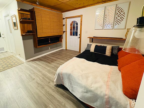 Living room with entertainment center and couch with pull out bed and extra storage compartment.