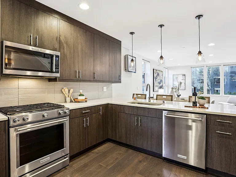 Chef's kitchen with large island, quartz waterfall counter, modern cabinets and high quality appliances.