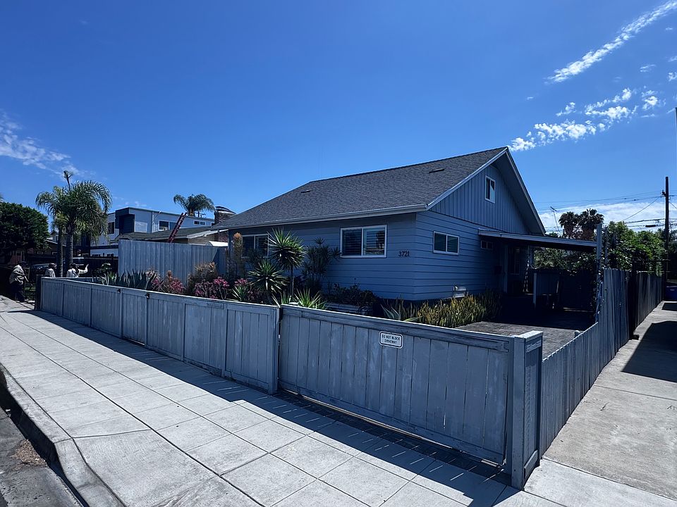 Front of the home. There's a motorized gate for ease accessing the front driveway and a carport. The front yard is low-maintenance.