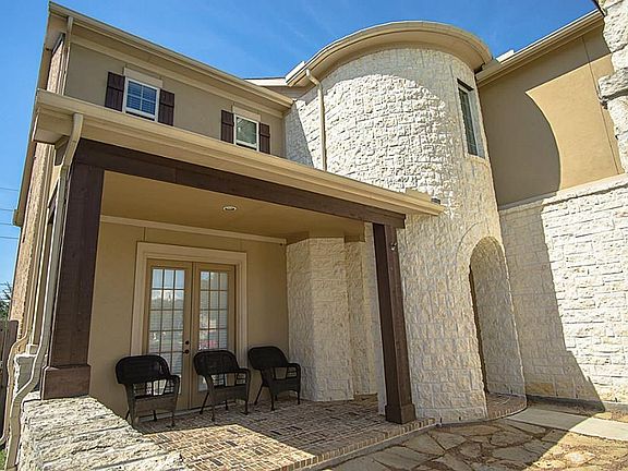 A quaint covered patio features a quiet place for a morning cup of coffee overlooking a fabulous courtyard!