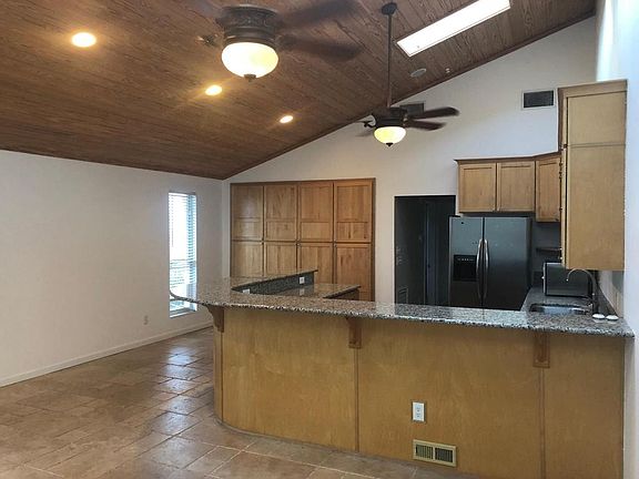 Open living area with vaulted ceilings, ample storage and skylights