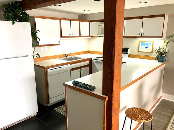 Kitchen in great room enjoys wide open western water, sky, mountain views