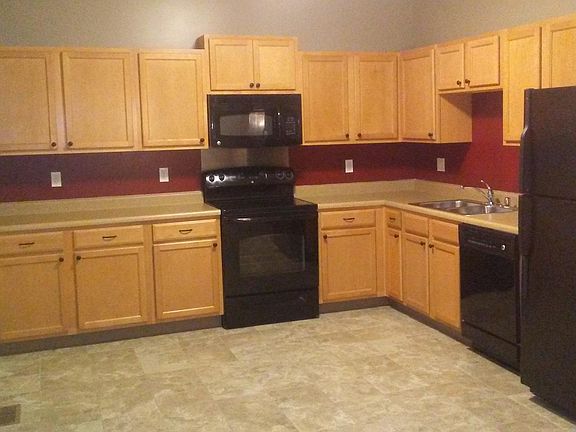 Large kitchen with matching appliances. Refrigerator has an ice maker. Kitchen sink has garbage disposal.