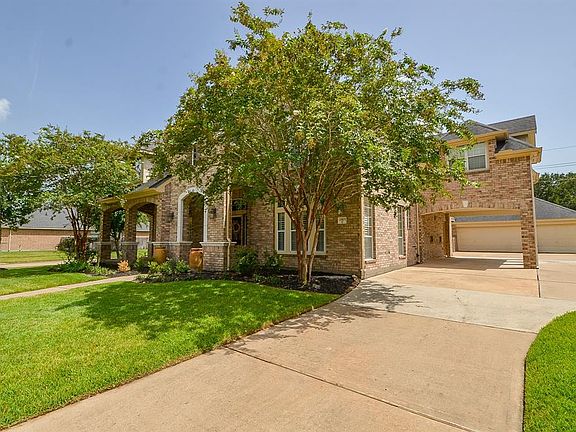 This house has a spacious driveway leading into the home's garage. It also has a porte-cochere connected to the driveway making it easier to enter and exit the house.