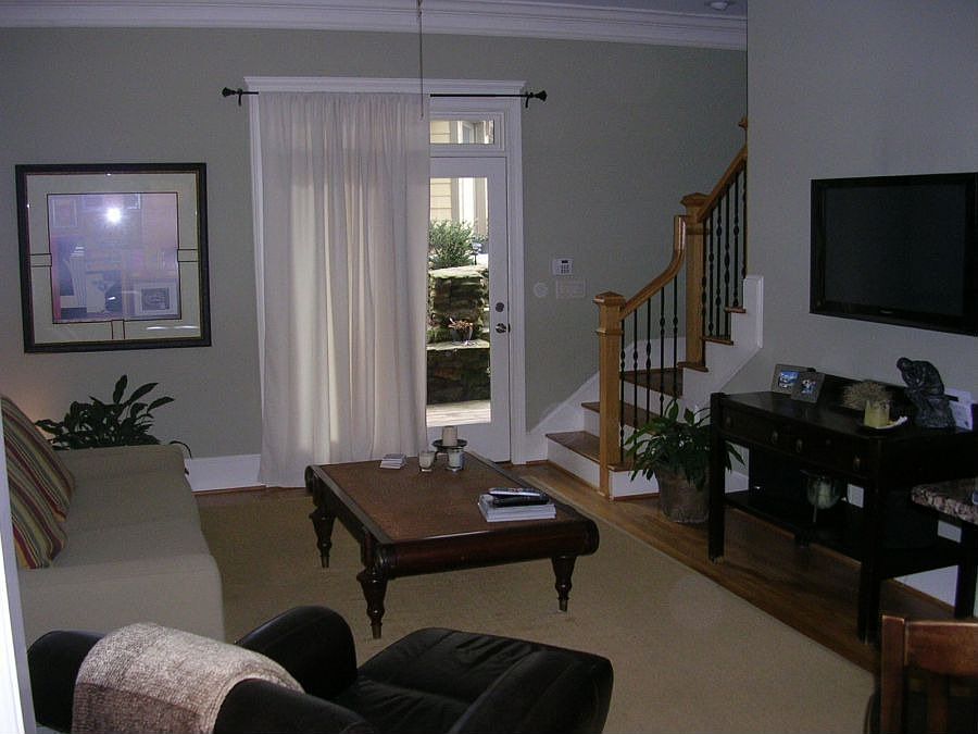 The spacious living area includes hardwood floors, plantation shutters, door to back deck and a view to the kitchen.