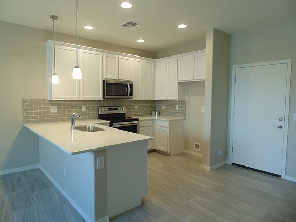 Kitchen includes quartz countertops and stainless steel appliances. Included side by side refrigerator is not shown in this photo.