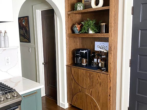 A custom-designed kitchen cabinet with a fully stocked coffee bar awaits, offering the perfect setup for your morning brew.