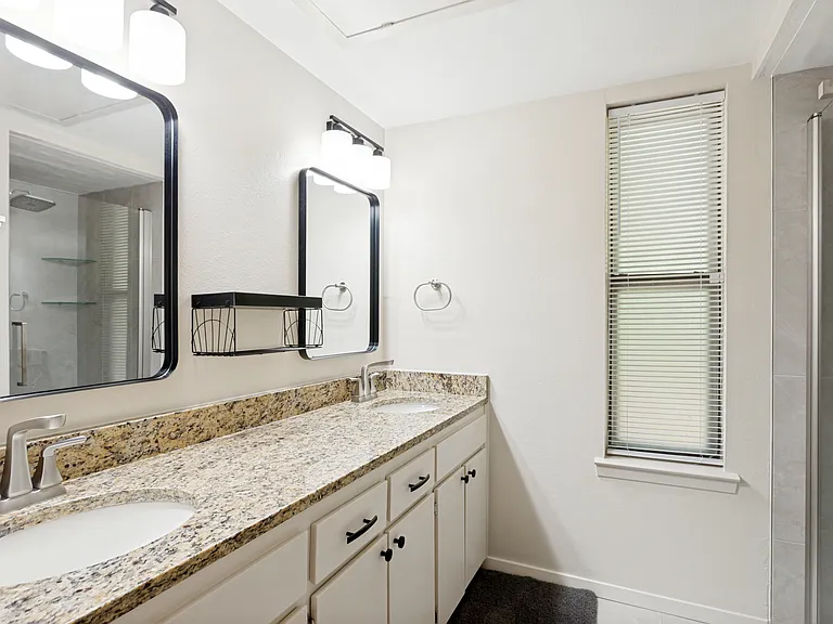 secondary bath with dual sinks and new tile shower and fixtures