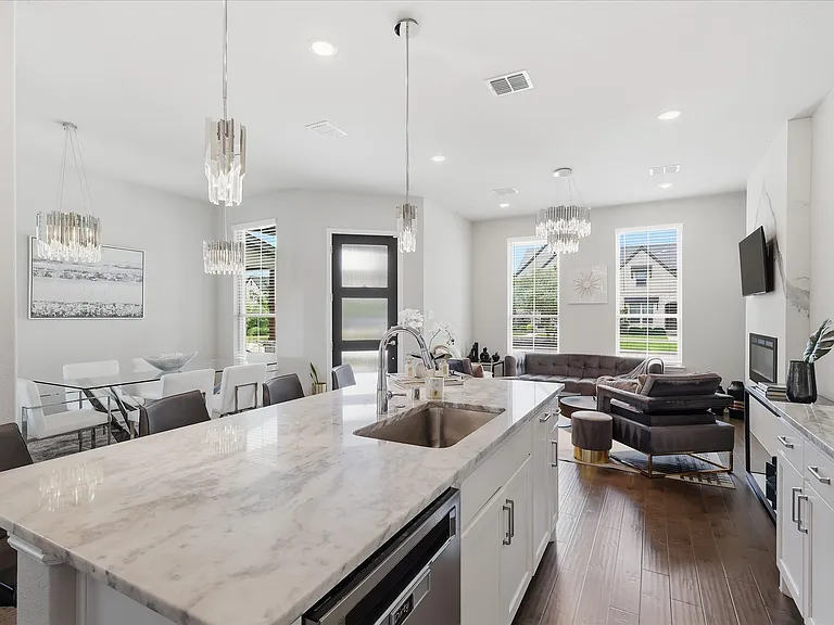 Kitchen island with a stainless steel undermount sink and quartz countertop.