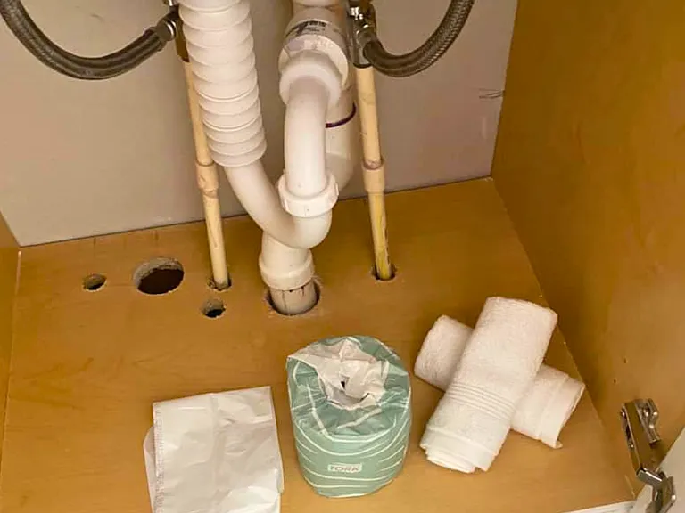 Bathroom stocked with towels, toilet paper, and trash bags.