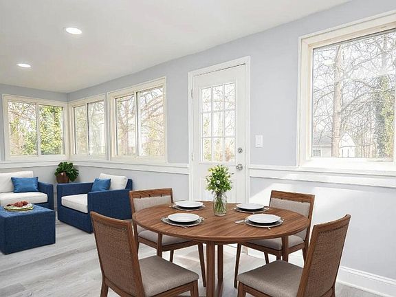 Newly updated dining area featuring modern flooring, fresh paint, and plenty of natural light