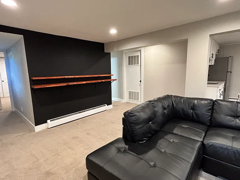 Living space includes new wooden shelves to complement bar stools or additional decor.
