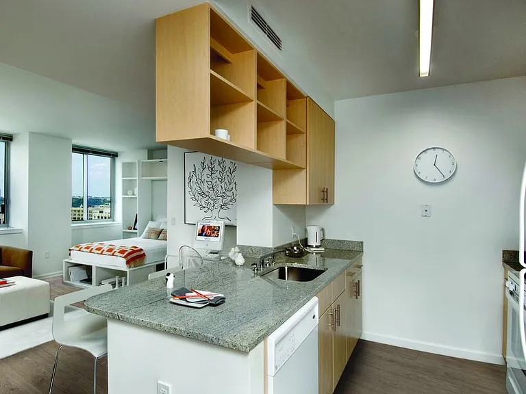 Classic II South kitchen with white appliances, grey granite countertops, oak cabinetry, and hard surface flooring