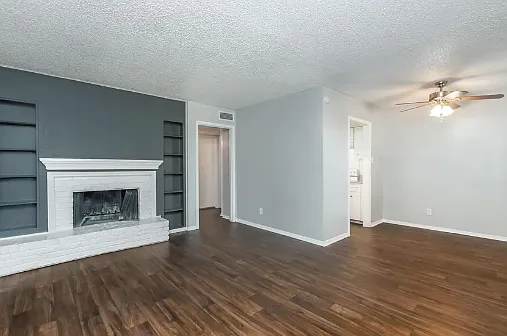 Bright and inviting living space with wood-style flooring and a cozy fireplace for a warm touch of comfort.