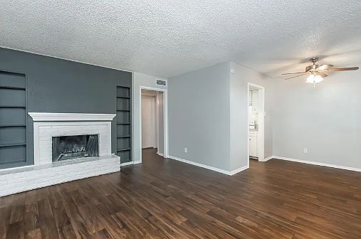 Bright and inviting living space with wood-style flooring and a cozy fireplace for a warm touch of comfort.