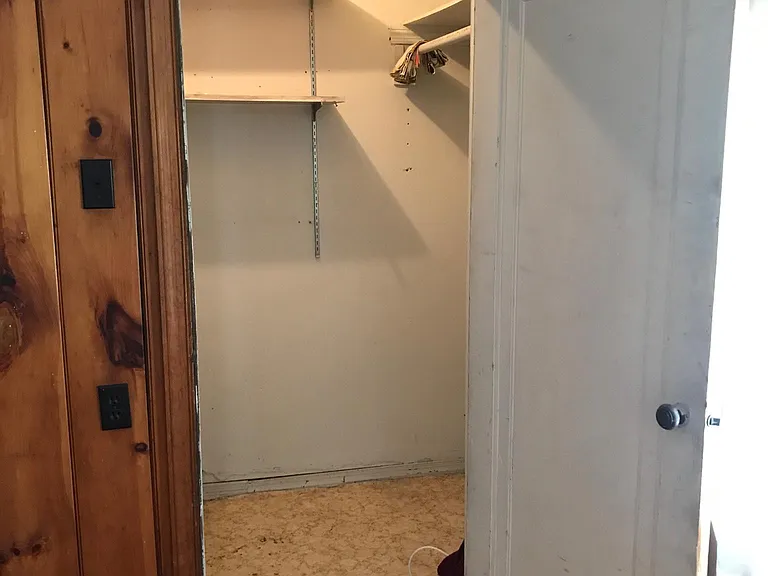 Coat closet and stairs to attic space located off den.