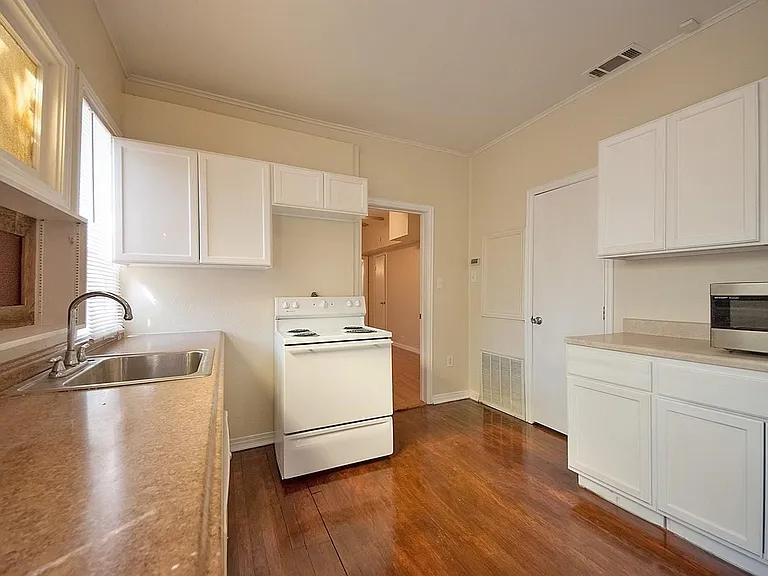 A cozy kitchen with white cabinets, a microwave and a stove, creating a clean and inviting cooking space.
