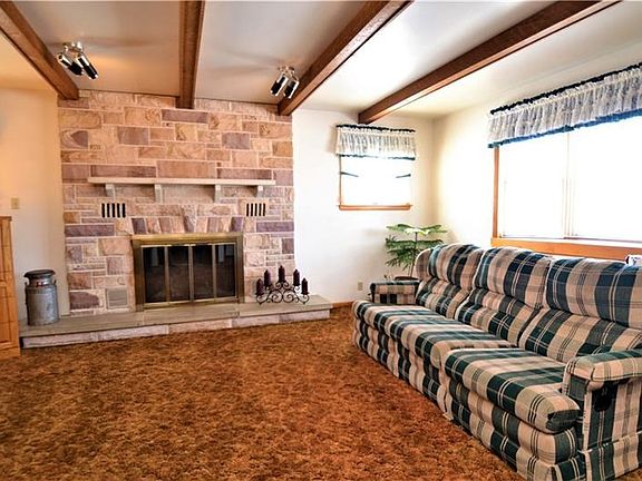 Wood Fire Place surrounded by Stone in the Living Room accent to wood beams